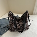 Large leopard print tote bag with black trim and shoulder strap on a cozy bed setup - Khaki