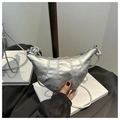 Detail of silver crescent crossbody bag with quilted texture and knotted strap detail - Silver