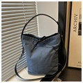 Detail der blauen Denim-Beuteltasche mit schwarzen Lederriemen und Schleife - Dunkelblau