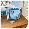 Close-up of light blue nylon crescent bag with black double zippers and wide strap - Blue
