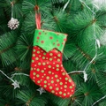 Calza di Natale rossa con pois verdi appesa all'albero di Natale per i regali - Rosso