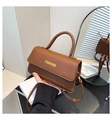 Detailansicht der braunen Handtasche mit Litschi-Muster und modischem Schriftzug - Braun