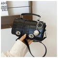 Detail of black crocodile pattern leather handbag with silver double locks and metallic charm - Black With Rabbit Pendant