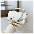 Close-up of white crocodile pattern leather mini bag with double metal turn-lock closure - Off-White with Pendant