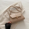 Borsa sottobraccio beige minimalista con fibbia dorata su un blazer crema - Cachi