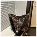 Nahaufnahme der Schultertasche mit Leopardenmuster, schwarzem Gurt und Goldschnalle - Braun