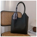 Detail of black lychee grain leather tote bag with silk scarf and embossed fashion text - Black