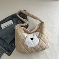 Beige quilted tote bag featuring a plush cartoon dog patch in a home lifestyle setting - Khaki