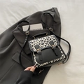 Zaino leopardato con dettagli in pelle nera e fibbie dorate sopra un blazer grigio - Nero
