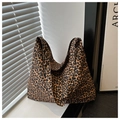 Leopard-Leinentasche auf weißem Tisch mit natürlichem Sonnenlicht und Schatten - Braun