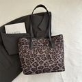 Große Shopper-Tasche mit Leopardenmuster und schwarzen Trägern auf grauem Sakko - Braun