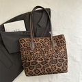 Große Shopper-Tasche mit Leopardenmuster und dunkelbraunen Trägern auf weißem Stoff - Braun