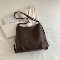 Bolso tote de cuero marrón oscuro con grabado de marca y correa ajustable sobre americana - Marrón