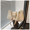 Dettaglio di una borsa sottobraccio color crema con grande fibbia in metallo dorato e design - Bianco