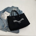 Borsa tote in tela nera con scritta Fashion Paris bianca su sfondo stile di vita - Nero
