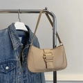 Schicke beige Unterarmtasche mit Goldschnalle am Kleiderbügel mit Jeansjacke - Khaki