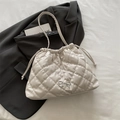 Cream quilted bucket bag with silver bow accent and adjustable drawstring strap - Off White