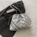 Silver quilted drawstring bucket bag with metallic bow on grey blazer and white fabric - Silver