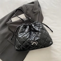 Chic black quilted bucket bag with a silver bow and sleek drawstring closure - Black