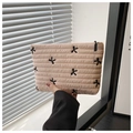 Detailansicht der aprikosenfarbenen gesteppten Kosmetiktasche mit schwarzen Schleifen-Stickereien - Hellrosa