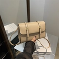 Borsa a tracolla quadrata beige con fibbia rotonda dorata e tracolla regolabile in mano - Cachi