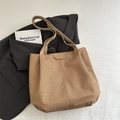 Minimalistische gewebte khakifarbene Tragetasche mit Lederetikett auf grauem Blazer - Braun