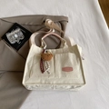 Off-white corduroy tote bag with pink label and cute bear charm in a stylish setting - With Pendant / Pink