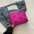 Quilted rose red makeup bag with black embroidered bows and zipper on denim background - Rose Pink