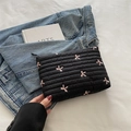 Quilted black nylon clutch featuring pink embroidered bows and striped texture - Black