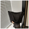 Detail of the high-density crinkled nylon fabric and zipper closure on a black bag - Black