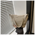 Detail shot of the beige pleated canvas underarm bag showing vertical wave textures - Khaki