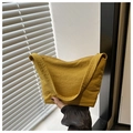 Close-up of a mustard yellow canvas hobo bag with a wide shoulder strap and zip closure - Yellow