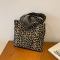 Grande borsa shopper in tela con stampa leopardata e ampi spallacci su tavolo in legno - Marrone