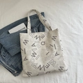 White minimalist tote bag with all-over black letter prints and double top handles - Off White