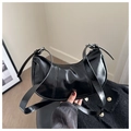 Detalle del bolso medialuna en charol negro con correa ajustable de hebilla plateada - Negro