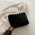 Chic black faux fur clutch bag with vertical stripe design on a beige blazer background - Black