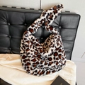 Bolso de hombro con estampado de leopardo en piel sintética sobre un sofá de cuero - Caqui