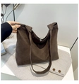 Detail of a dark brown suede tote bag with knotted handles on a light herringbone coat - Coffee