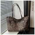 Dettaglio della grande borsa tote leopardata su una scrivania con luce naturale - Marrone