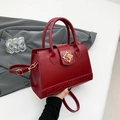 Elegant burgundy crocodile texture handbag with gold floral twist lock and shoulder strap - Red