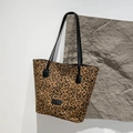 Modische Tragetasche mit Leopardenmuster und schwarzen Trägern auf einem Steinsockel - Kleiner Leopard Braun