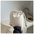 Detalle del bolso de cubo crema con cordón, diseño de doble capa y correa delgada - Blanco