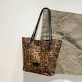 Stilvolle Tragetasche mit Leopardenmuster und schwarzen Trägern auf grauem Stein - Großer Leopard Braun