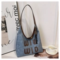 Detail of blue denim tote bag featuring brown WIO WIO lettering and a tennis racket charm - With Charm / Denim Blue