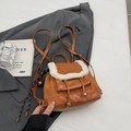 Close-up of vintage brown suede mini backpack with plush white fleece trim and buckle - With Pendant / Brown