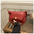 Primer plano de bolso de hombro de cuero rojo con hebilla dorada y correa con nudo único - Rojo