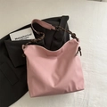 Pink soft leather tote bag featuring a decorative brown and white braided shoulder strap - Pink