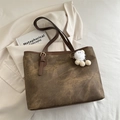 Large vintage brown tote bag with marble texture and plush charm in a lifestyle setting - With Pendant / Brown