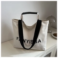 Detail of canvas tote bag showing black FANYISSA print and durable woven shoulder straps - White