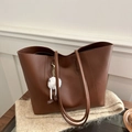 Caramel brown leather tote bag on beige knit blanket with cute white plush charm - With Pendant / Red Brown